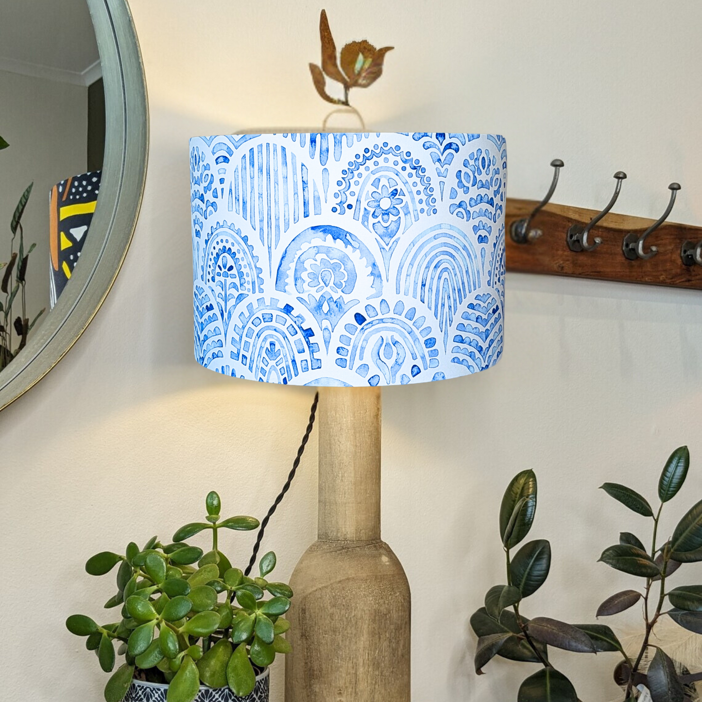 Blue & White Hamptons lampshade by Emotive Collection, shown on a wooden base with the light switched on, showcasing elegant coastal patterns in soothing hues. Handcrafted in Australia to bring a serene vibe to your space