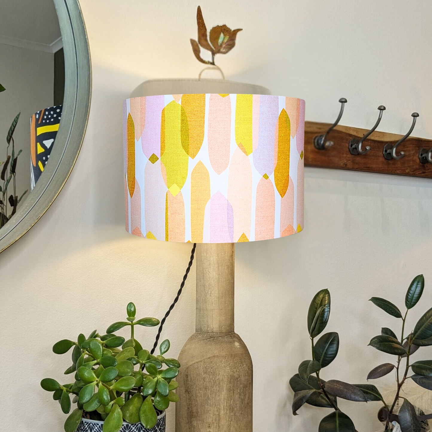 Mid Century Droplets Ivory lampshade by Emotive Collection on a wooden lamp base with the light switched on, featuring an elegant design by Cecilia Mok. A stylish, minimalist piece crafted by hand in Australia.