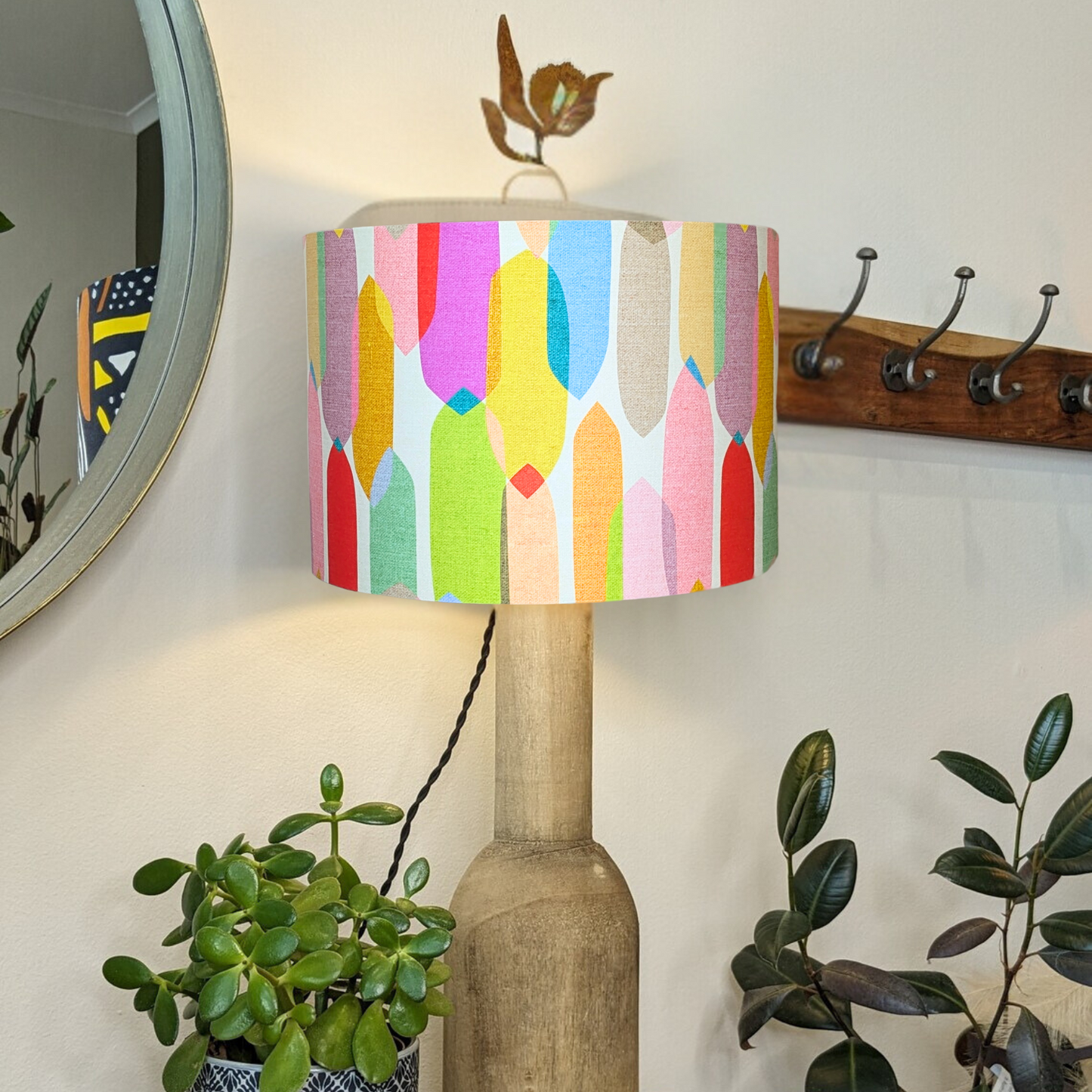 On a wooden lamp base with the light turned on is showcased the handmade Multi-Colour Mid-Century lampshade, designed by Cecilia Mok for Emotive Collection. Featuring a dynamic geometric design, it’s meticulously crafted in Australia.