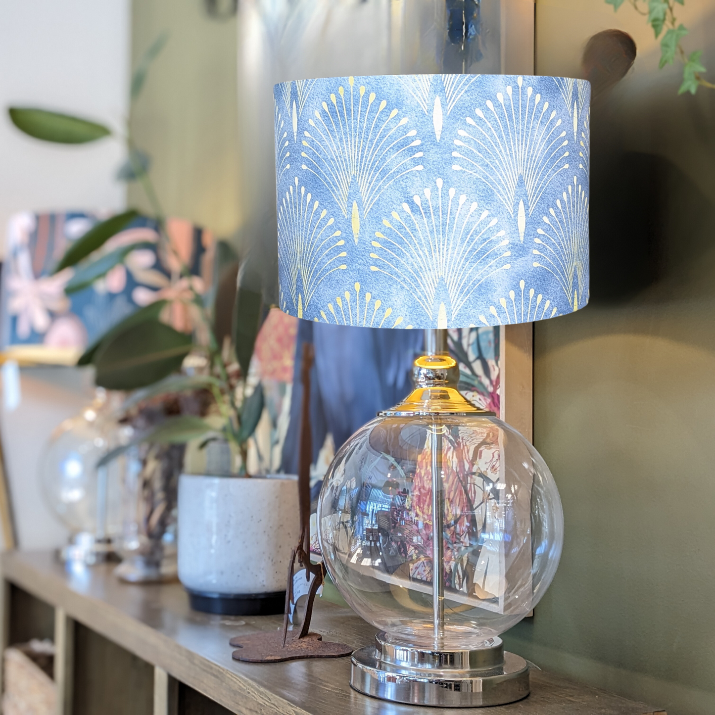 Handmade Gatsby lampshade on a glass lamp base by Emotive Collection, featuring a vibrant Gatsby art deco print on a blue background