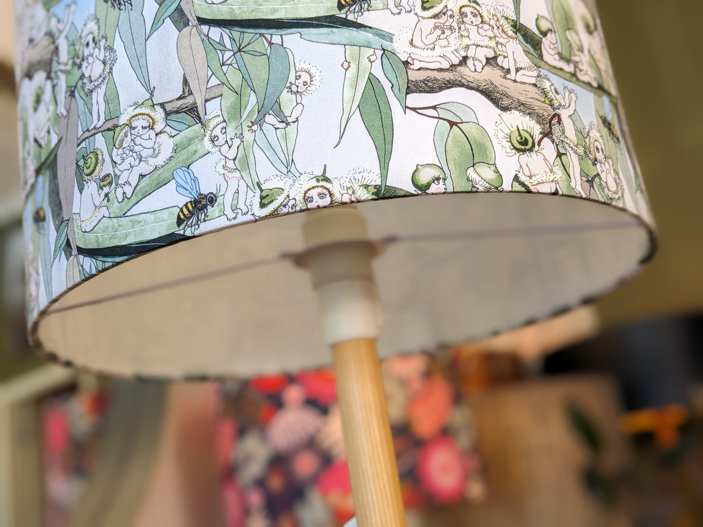 Close up of the lampshade fitting for Emotive Collection's Handmade Vintage May Gibbs lampshade, featuring beloved Australian characters Snugglepot and Cuddlepie with native flora on a cheerful yellow background. Expertly crafted in Australia, this lampsh