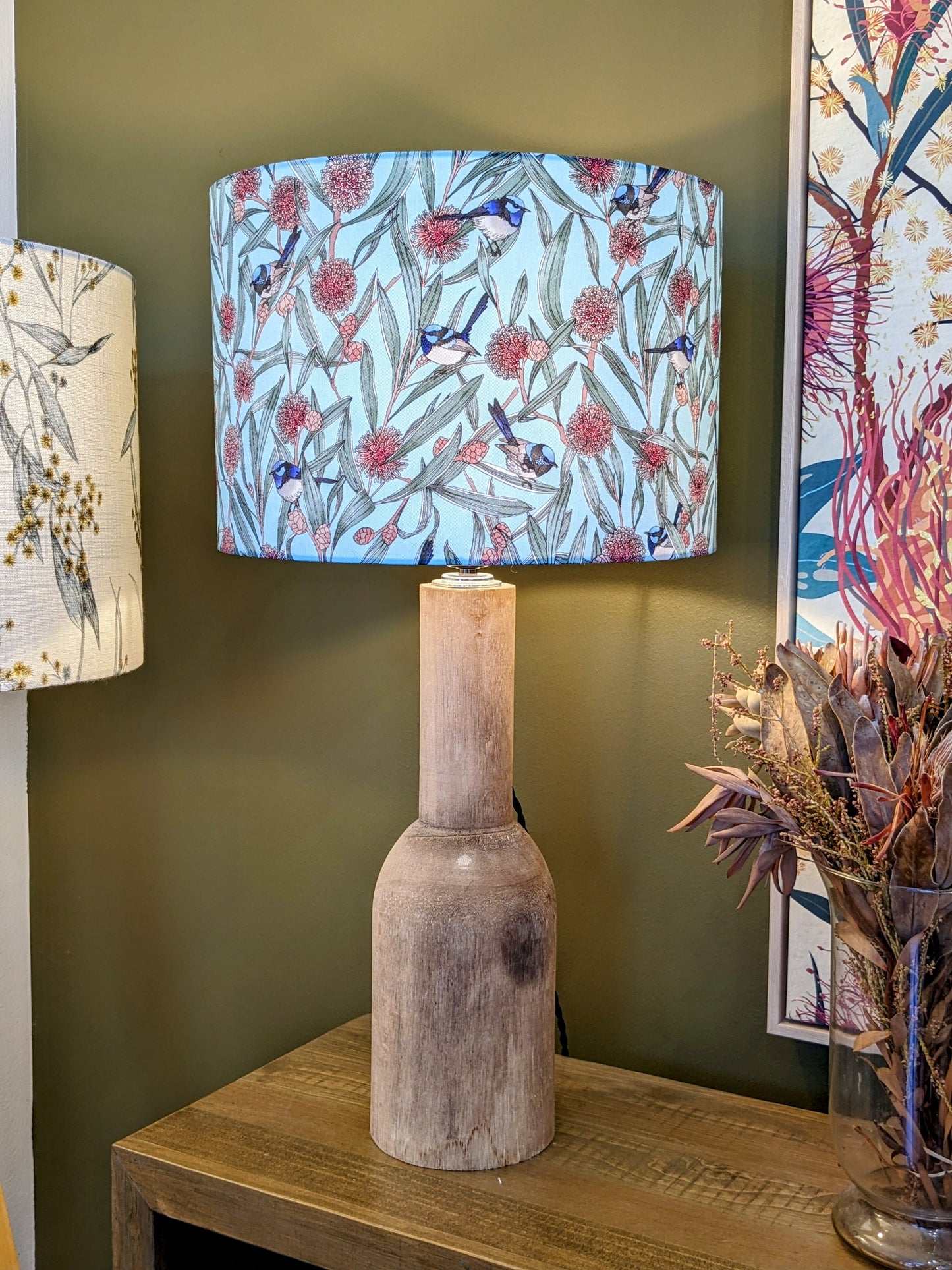 "Handmade Blue Wren & Hakea lampshade by Emotive Collection shown on a wooden lamp base, featuring a colorful Australian design by Victoria McGrane from The Scenic Route. Crafted in Australia for nature-inspired elegance