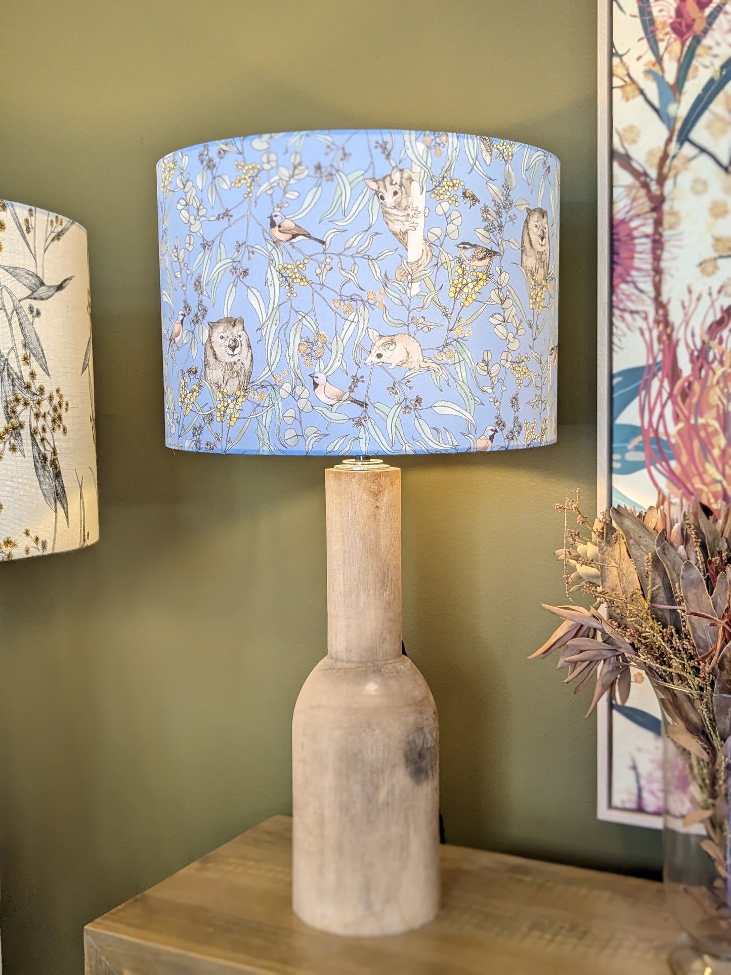 Handmade Wombat & Wattle lampshade on a wooden lamp base by Emotive Collection, featuring a delightful Australian design by Victoria McGrane from The Scenic Route. Crafted in Australia for a charming, nature-inspired lighting piece."