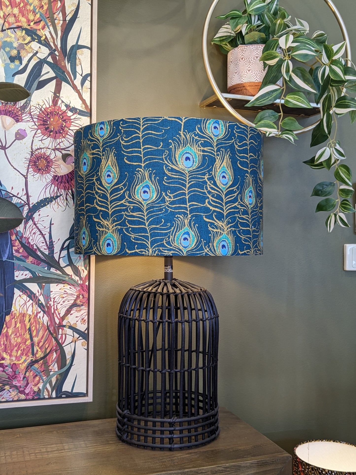 Peacock Feather Nouveau lampshade by Emotive Collection on a Black lamp base, showcasing a striking peacock feather design in gold tones against a blue background. Created by Australian artist Cecilia Mok and handcrafted with care in Australia.
