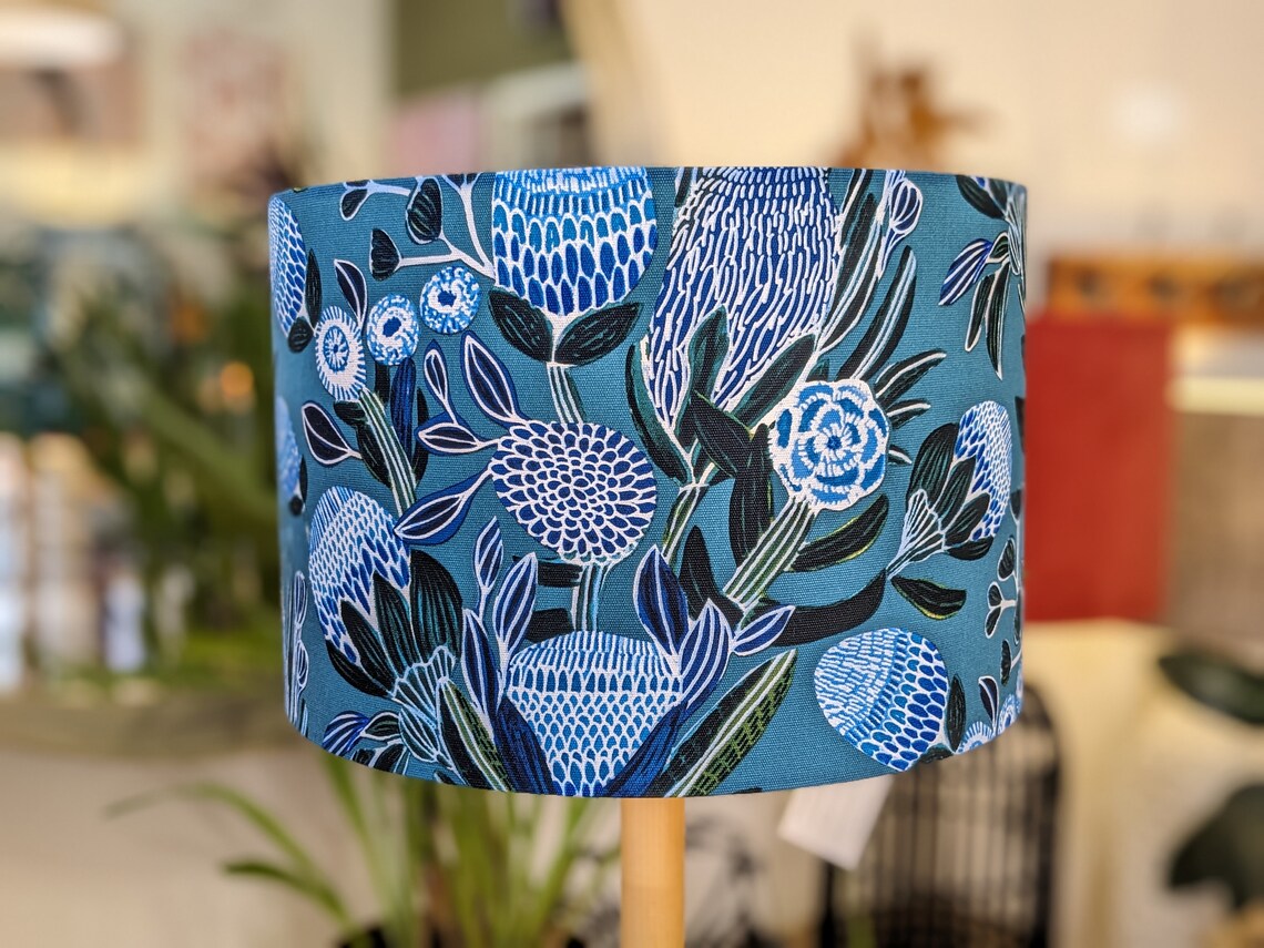 Emotive Collection's Banksias Blue lampshade showcases a unique Banksia flower design in blue shades. Designed by Kirsten Katz, handmade in Australia.