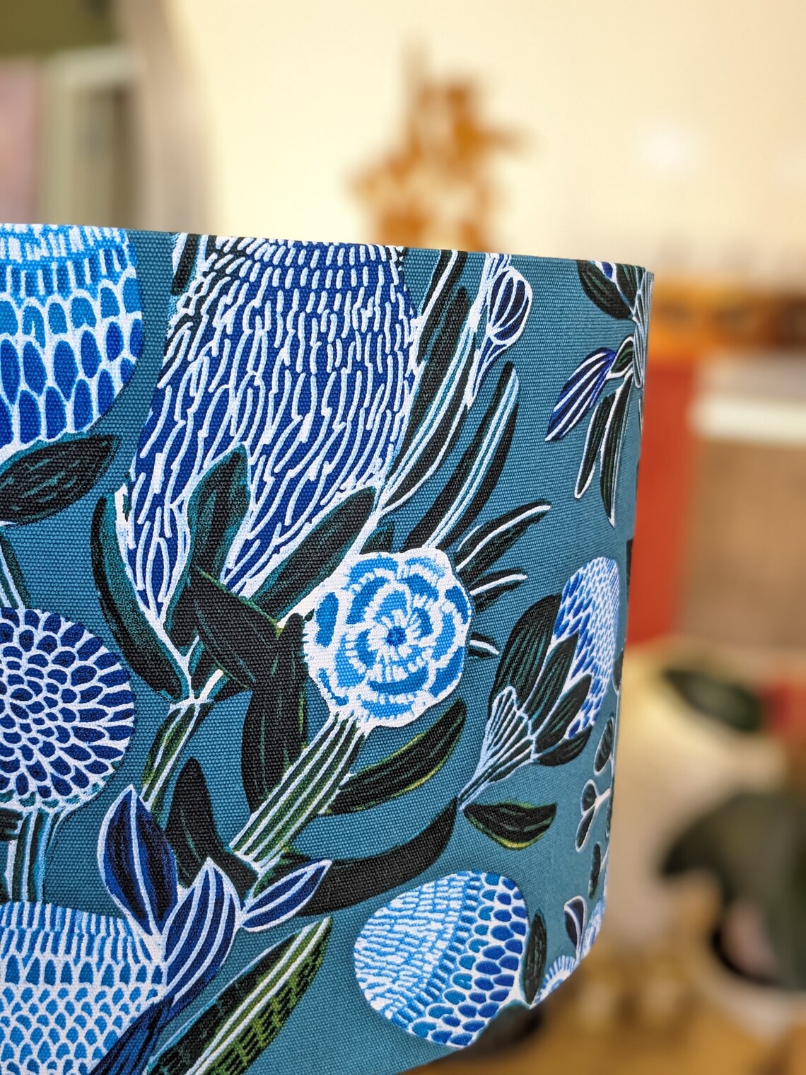 Elegant Banksias Blue lampshade by Kirsten Katz, featuring bold blue Banksia flowers. Handmade with premium quality in Australia by Emotive Collection