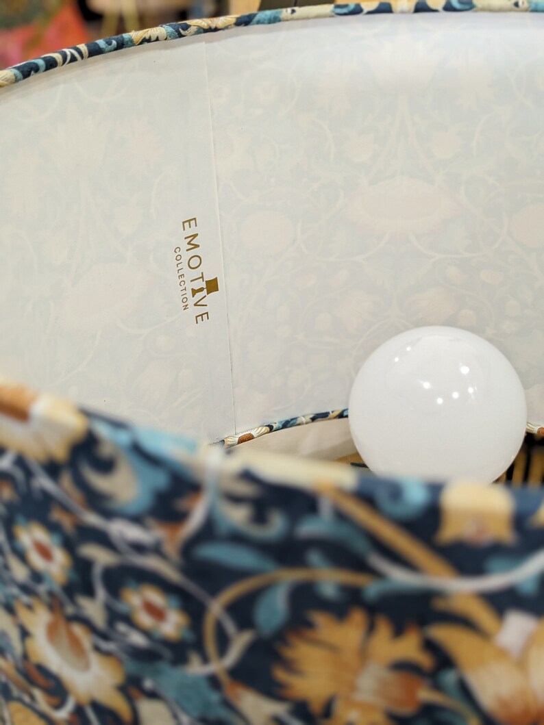 Close-up of the William Morris Lodden Lampshade from Emotive Collection, featuring floral-patterned fabric and a visible white bulb, which highlights its artistic elegance.