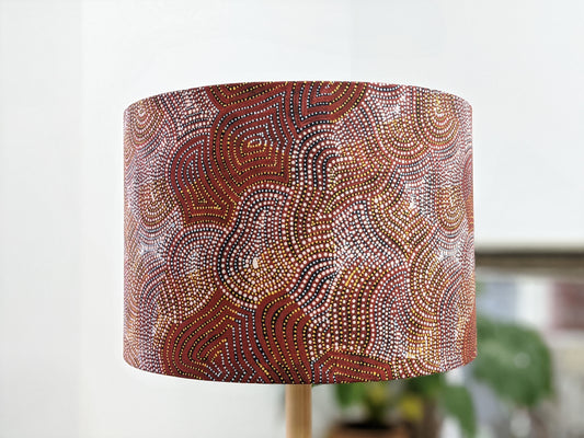 The Warlu Mina Mina Jukurrpa (Ngalyipi) lampshade by artist Mekeisha Napanangka Martin features vibrant Indigenous Aboriginal dotted patterns and swirling lines in red, white, yellow, and green.
