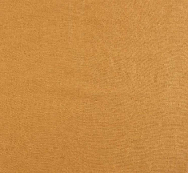 A close-up of Emotive Collection’s Dark Mustard Premium Linen Lampshade shows plain, light brown linen with a subtle woven texture—premium quality, no visible patterns. Ideal for Australian Made décor.