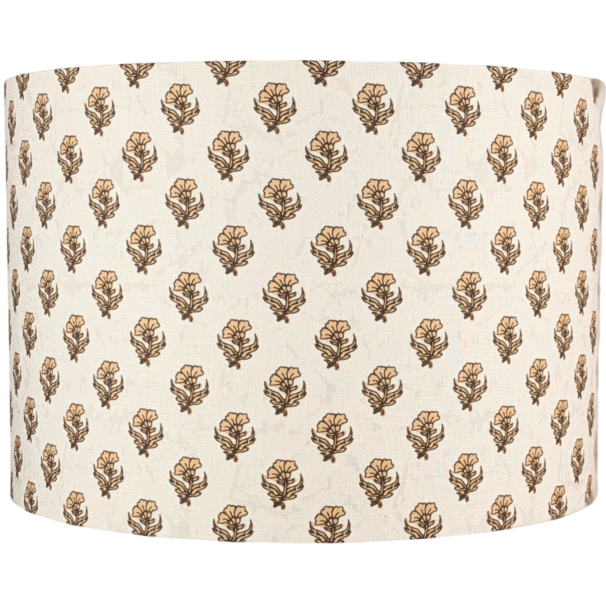 The Ishani Indian Block Print Lampshade by 100% Premium Linen is a cream cylindrical linen shade adorned with evenly distributed brown and beige floral patterns, evoking traditional handcrafted Indian designs.