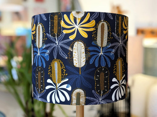 Handmade Midnight Banksia lampshade by Emotive Collection, featuring a striking design by Australian artist Jocelyn Proust. The lampshade showcases Banksia flowers against a dark background, adding elegance to any space. Crafted with care in Australia.
